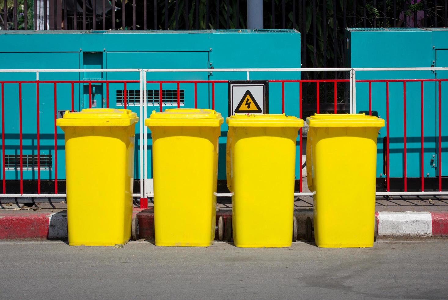 giallo spazzatura bidone nel il strada accanto il passerella foto