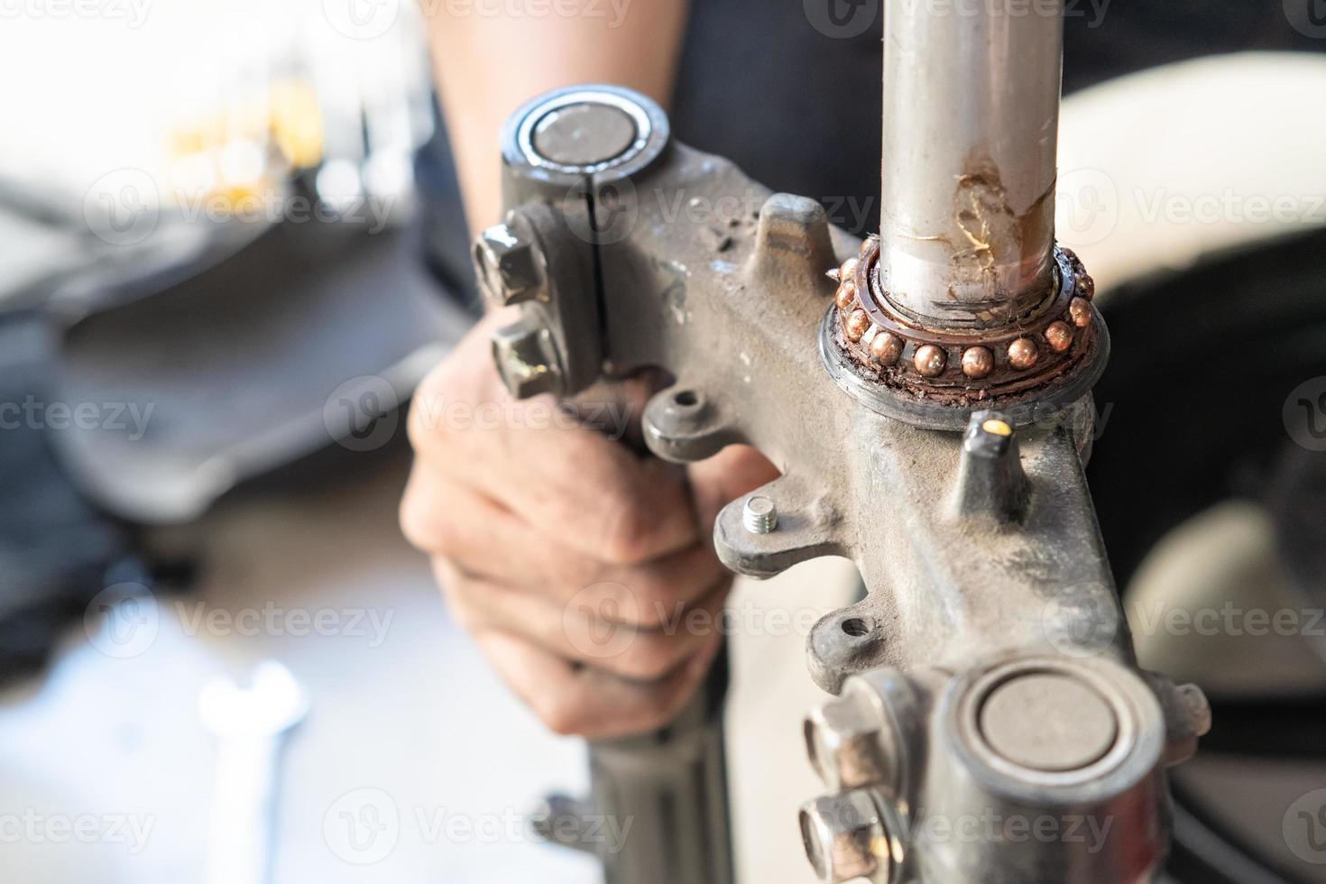 meccanico ispezionare e regolare motociclo timone testa cuscinetti, Manutenzione, riparazione motociclo concetto nel box auto .selettivo messa a fuoco foto