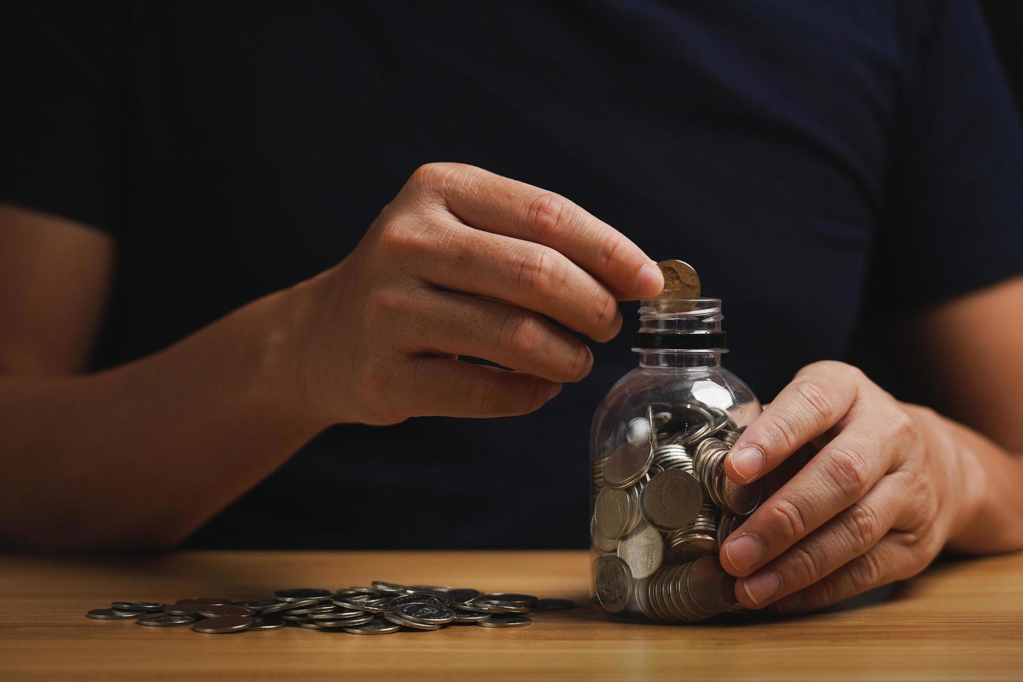 uomo d'affari tenuto il i soldi nel il porcellino banca su il tavolo. finanziario stabilità gestione concetto. risparmi e pensioni, raccolta i soldi, finanziario pianificazione foto