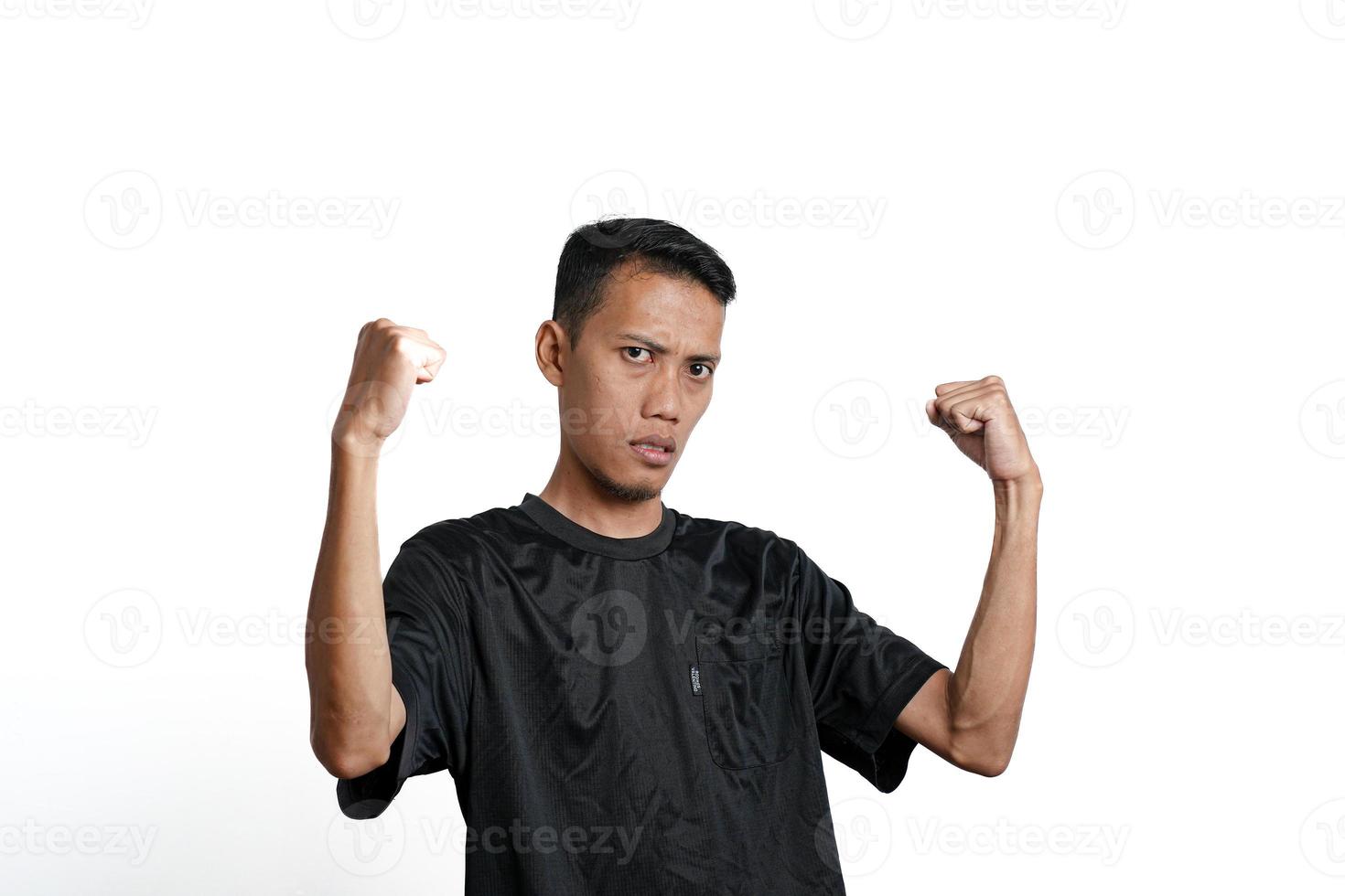 asiatico uomo indossare nero formazione maglietta, mostrando un' forte posizione con sollevato braccia e muscoli. isolato di bianca sfondo foto