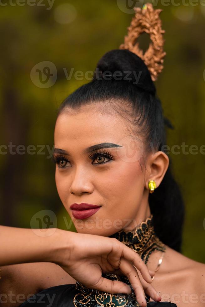 il feroce viso di un indonesiano donna indossare trucco su sua viso e un' nero costume dopo un' danza prestazione foto