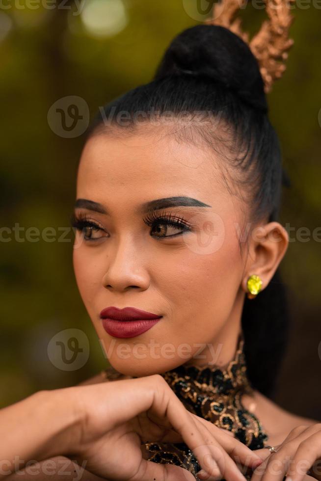 bellissimo asiatico donna con trucco e legato nero capelli indossare un' pezzo di nero gioielleria prima l'esecuzione danza su il palcoscenico foto