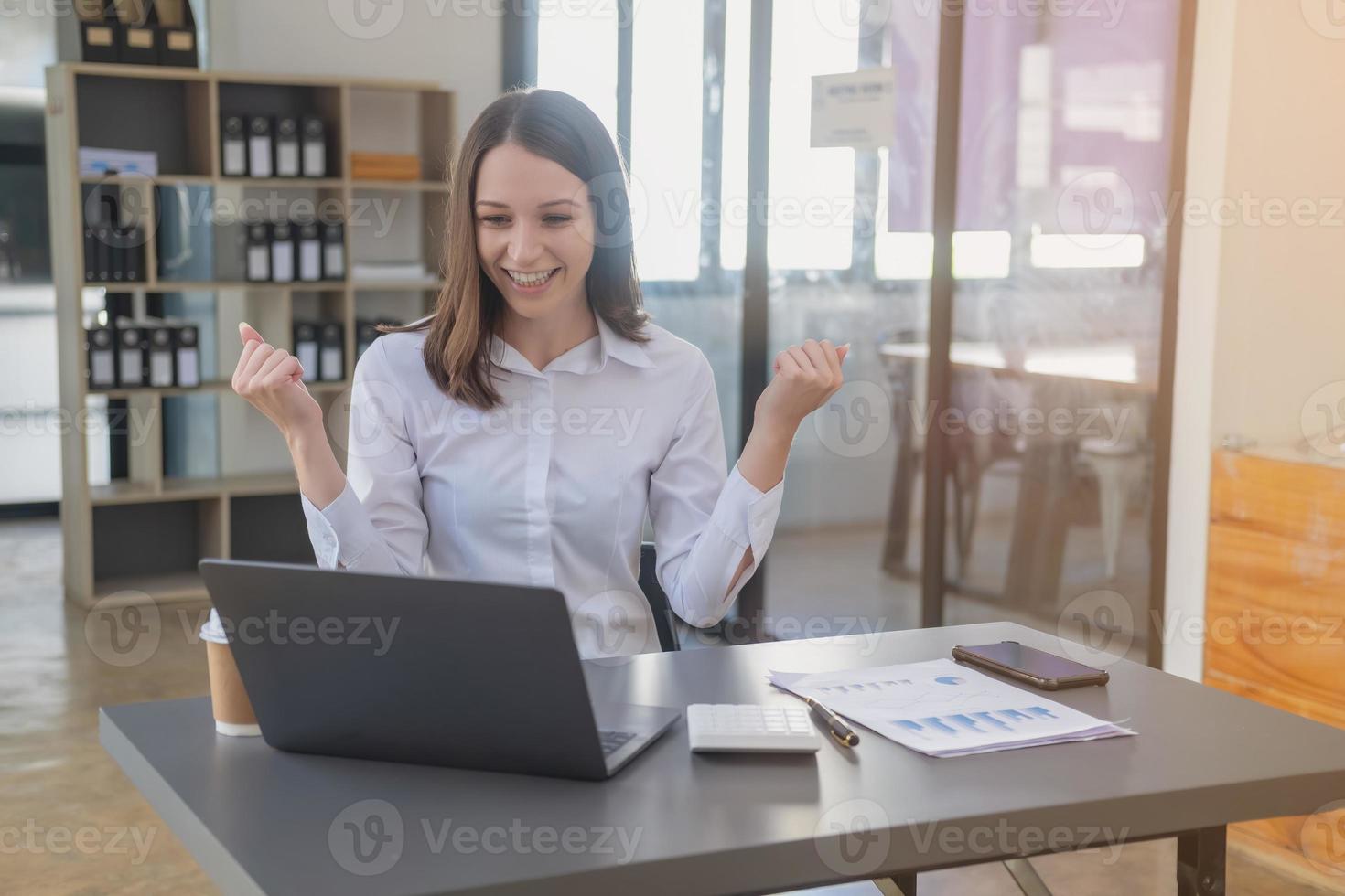 marketing, finanza, contabilità, pianificazione. caucasico donna d'affari Tenere mobile Telefono e mostrando buona volontà nel cliente unendo attività commerciale con azienda per aumentare profitto di il computer portatile ufficio e documenti foto