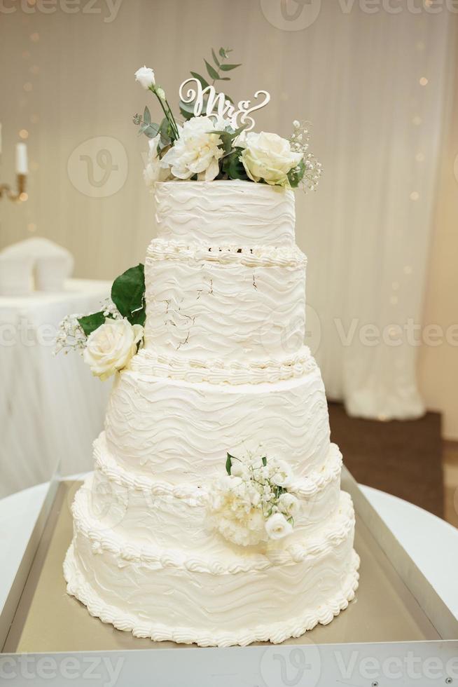 lusso bellissimo nozze bianca torta con bianca Rose a nozze ricezione. nozze giorno foto