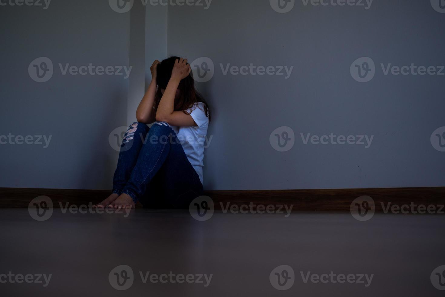 un' ragazza seduta nel un' buio angolo il camera solo è avendo i problemi. foto
