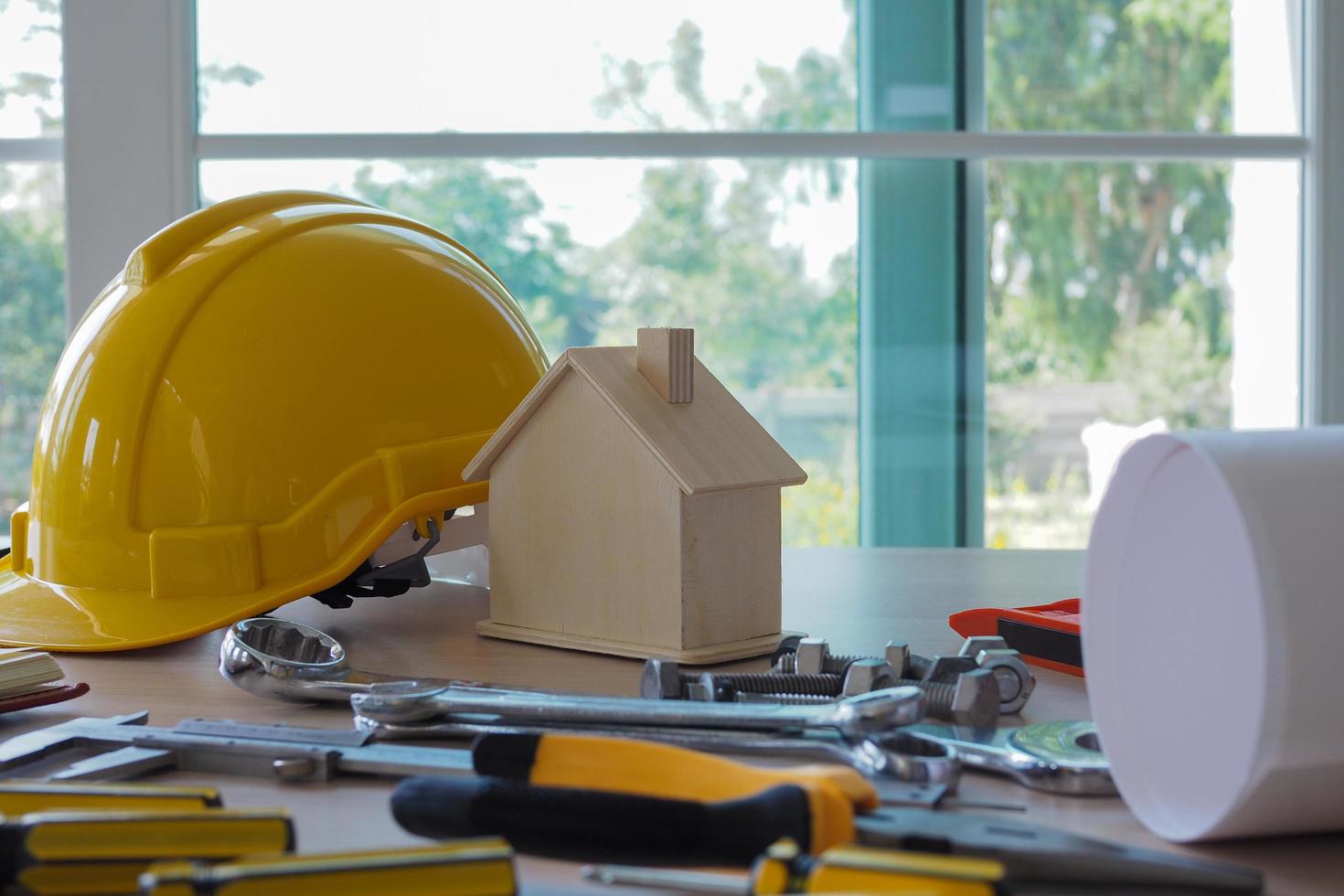 utensili e attrezzatura Usato nel costruzione. posto su il scrivania ,difficile cappello costruzione piani su di legno tavola edificio concetto. foto