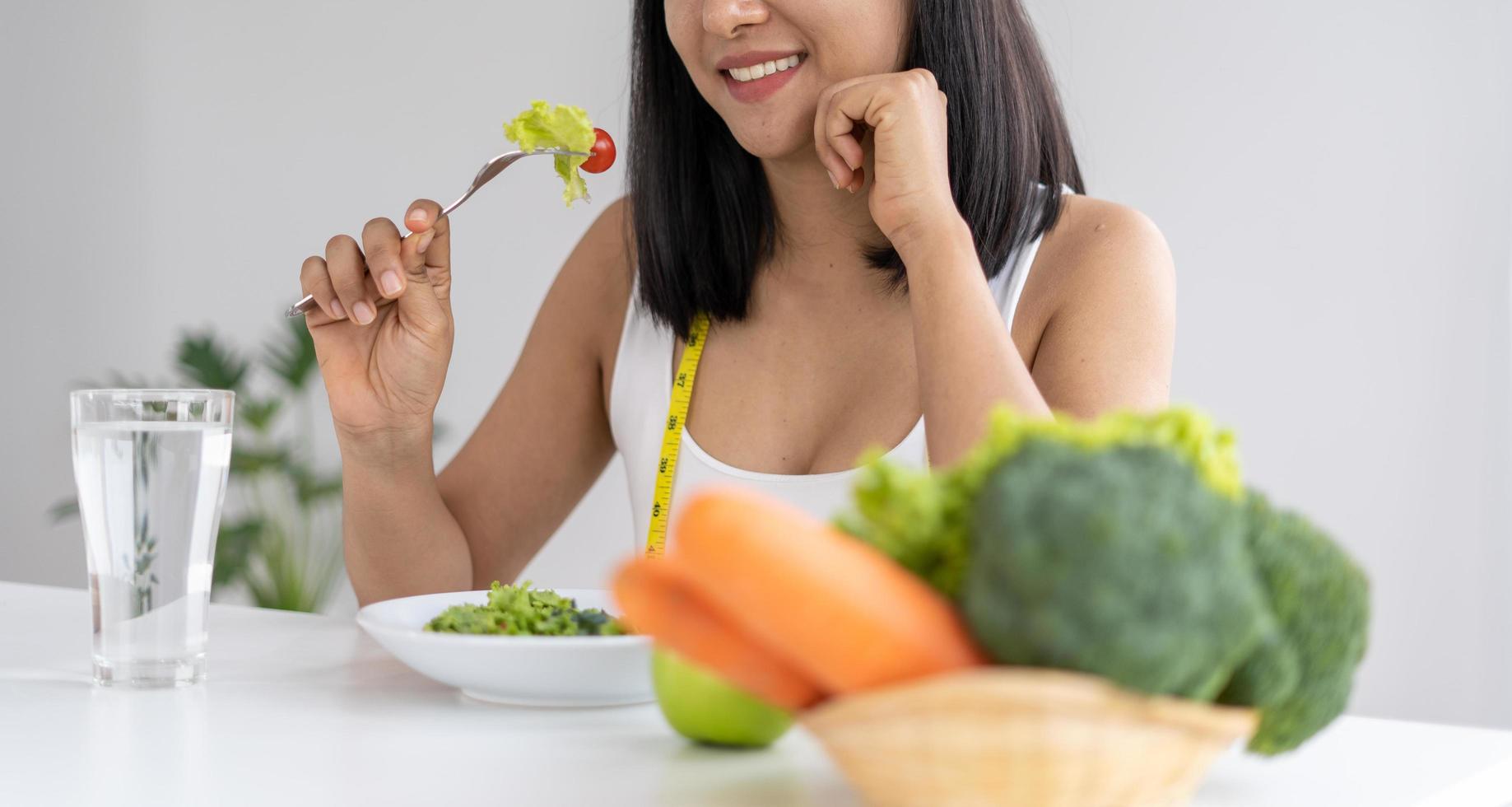 bellissimo asiatico donne siamo godendo mangiare insalata per perdere il peso. salutare giovane donna mangiare verdura insalata. dieta , salutare cibo concetti. foto