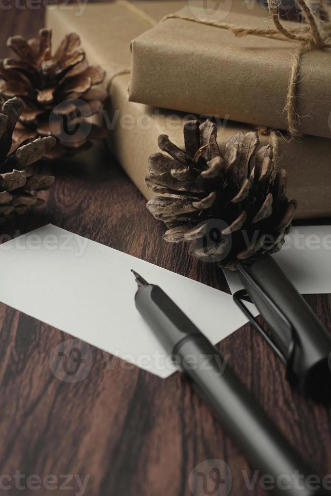 regalo scatole avvolto nel riciclato carta e regalo carte, nuovo anno regalo scatole posto su un' di legno tavolo, un' copyspace e un' Marrone Natale regalo scatola. foto