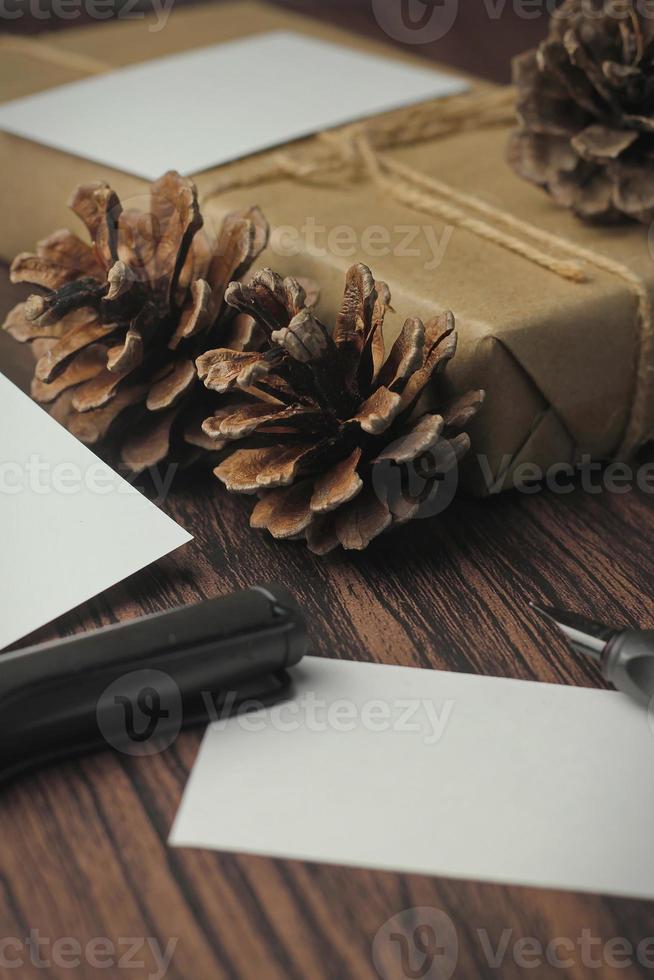 regalo scatole avvolto nel riciclato carta e regalo carte, nuovo anno regalo scatole posto su un' di legno tavolo, un' copyspace e un' Marrone Natale regalo scatola. foto