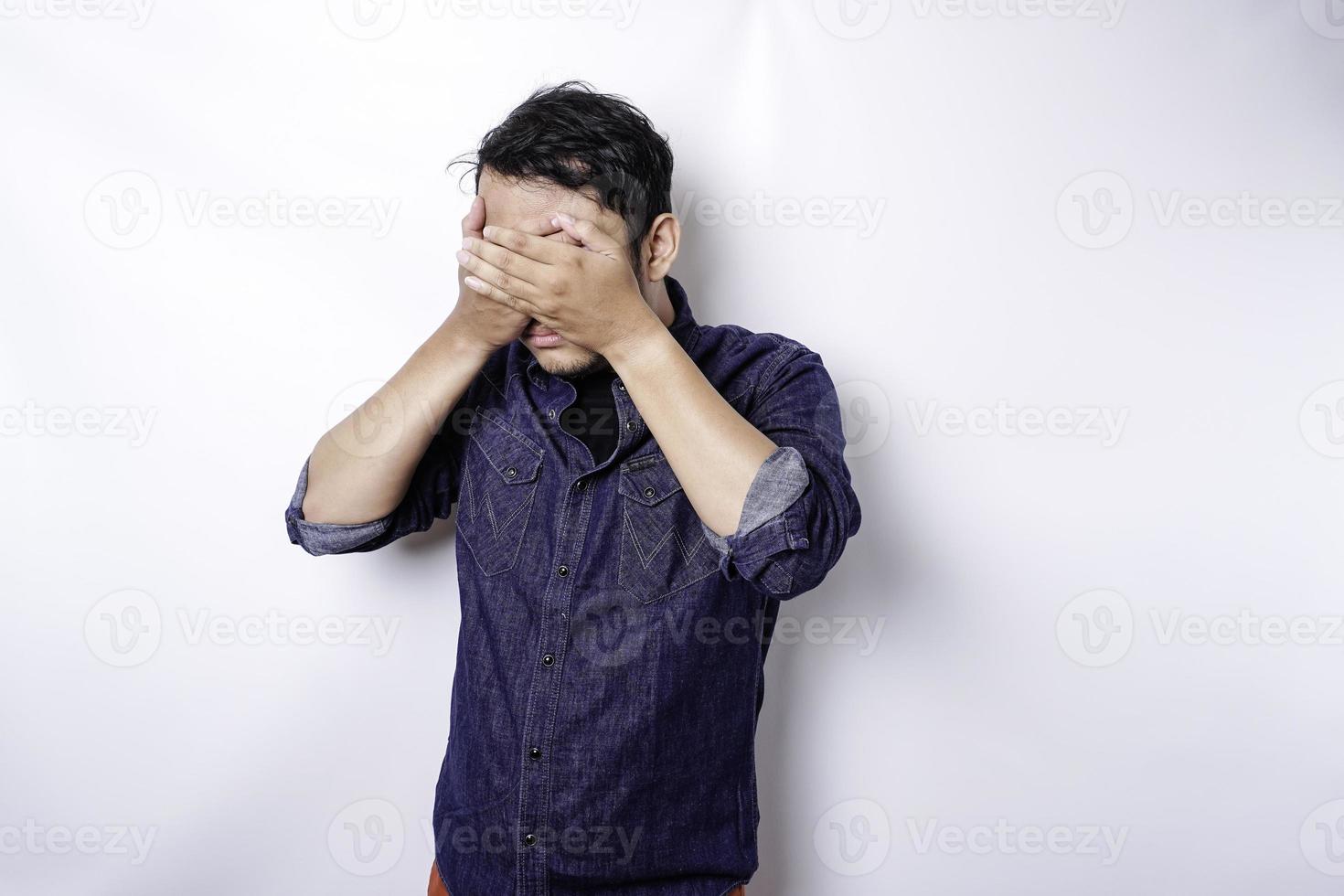 un' ritratto di un asiatico uomo indossare un' blu camicia isolato di bianca sfondo sembra depresso foto