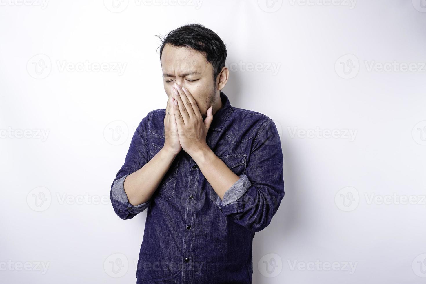 un' ritratto di un asiatico uomo indossare un' blu camicia isolato di bianca sfondo sembra depresso foto