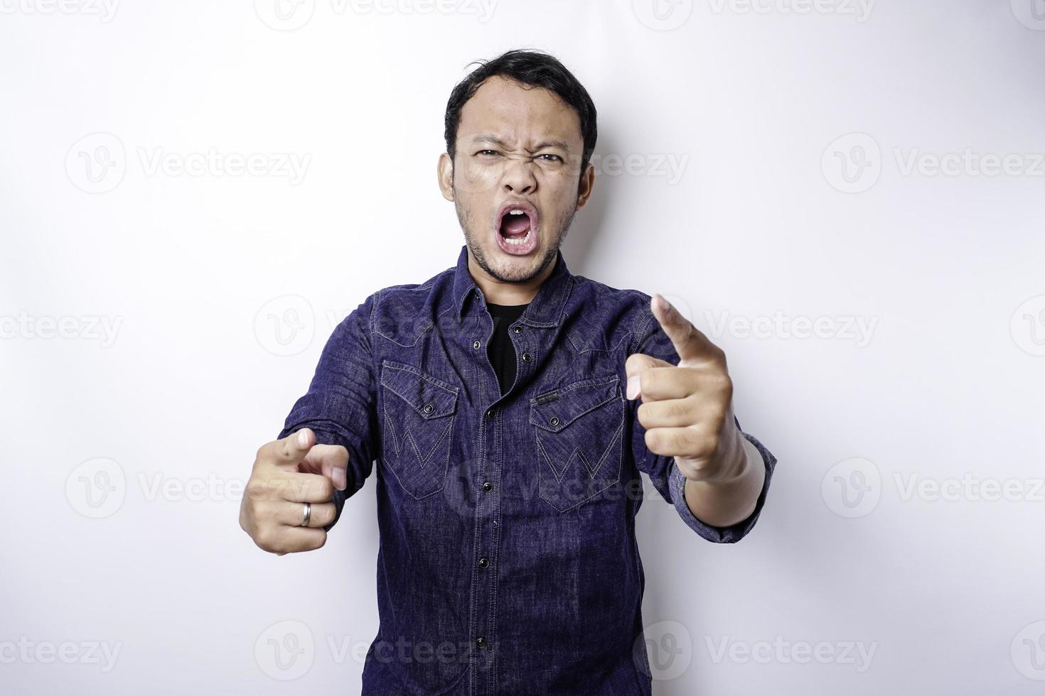il arrabbiato e pazzo viso di asiatico uomo nel blu camicia isolato bianca sfondo. foto