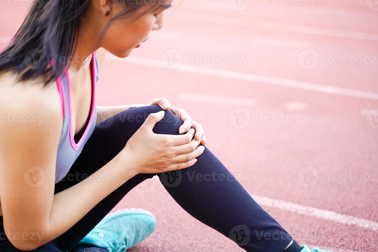avvicinamento Immagine di un' giovane donna mostrando un' ginocchio infortunio dopo un' allenamento. foto