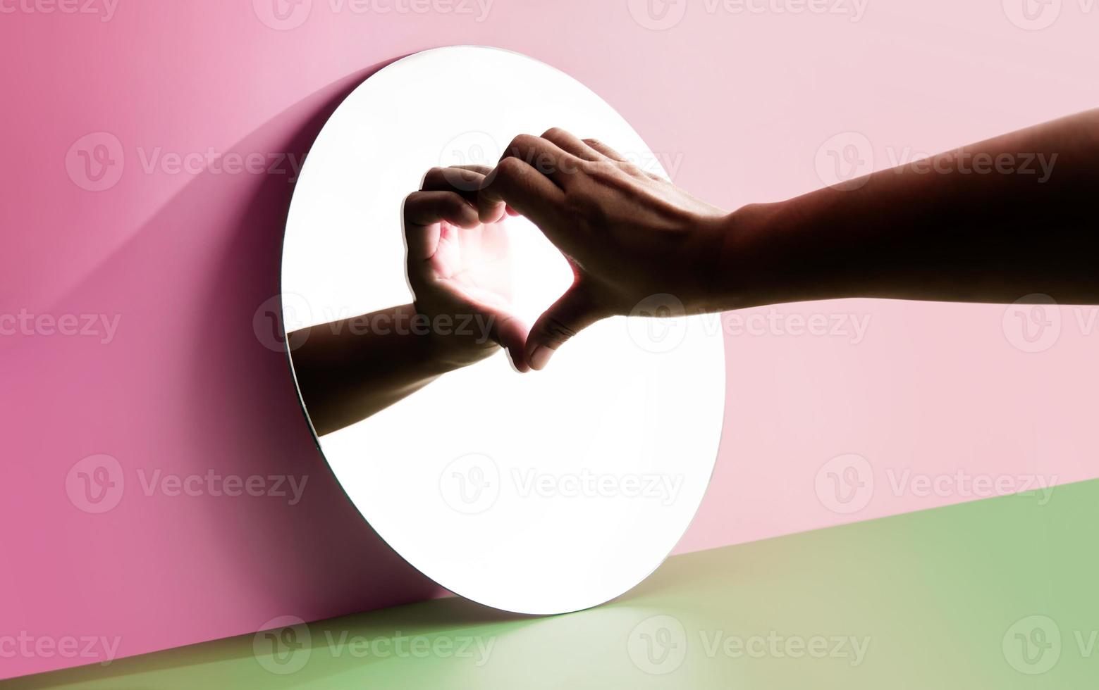 concettuale foto per amore e relazione. amore te stesso. singolo persona utilizzando mano per modulo un' cuore forma su il specchio. riempire te stesso con romanza su san valentino giorno