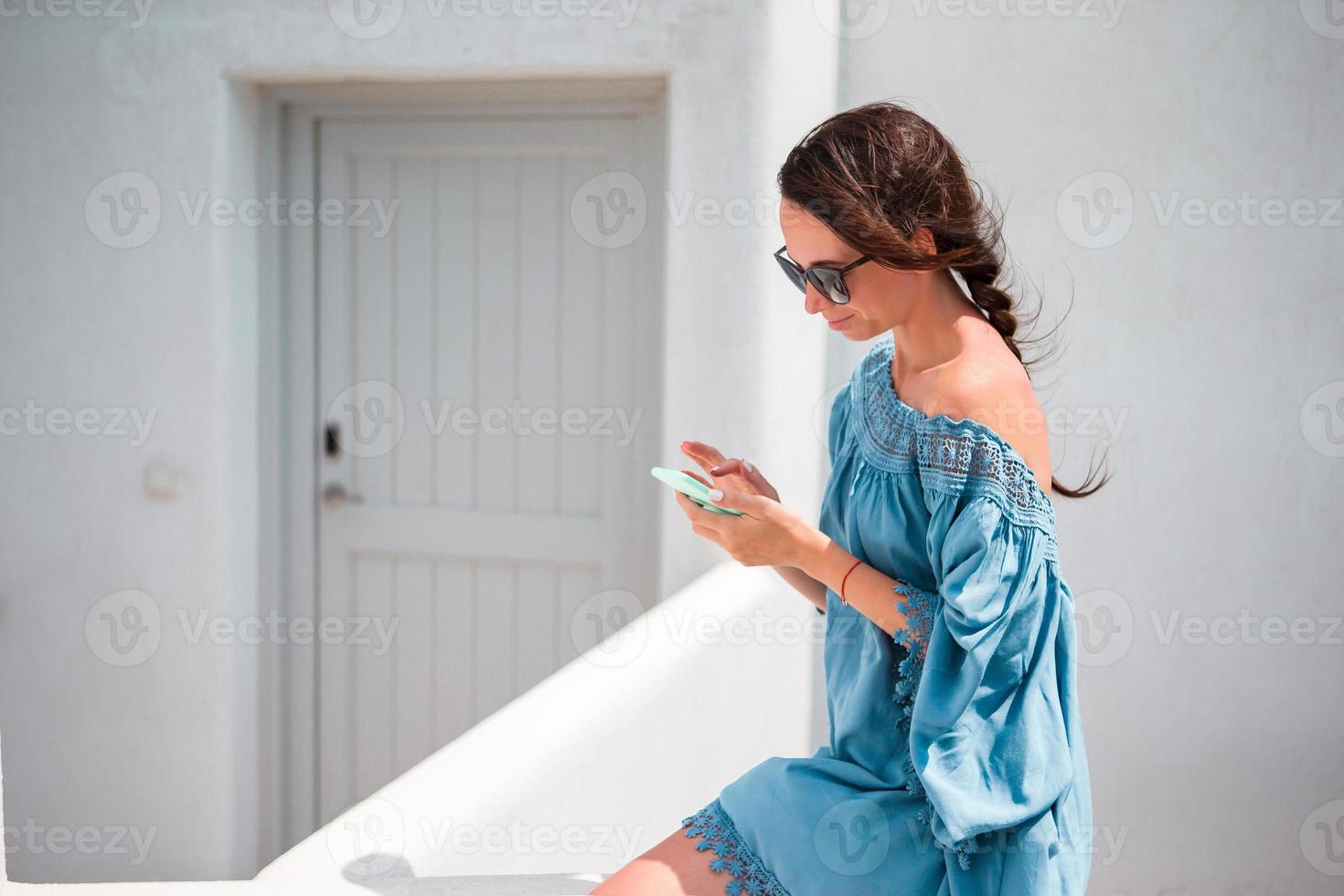 donna con cellulare all'aperto su il strada. turista utilizzando mobile smartphone. foto
