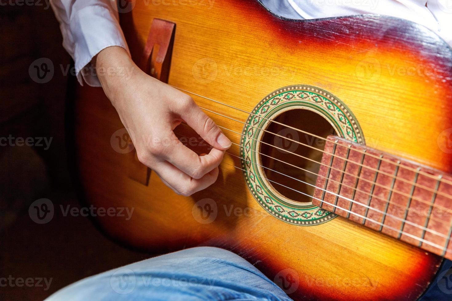 giovane fricchettone donna mani giocando chitarra a casa. adolescente ragazza apprendimento per giocare canzone e scrittura musica nel sua camera. passatempo, stile di vita, relax, strumento, tempo libero, formazione scolastica concetto. foto