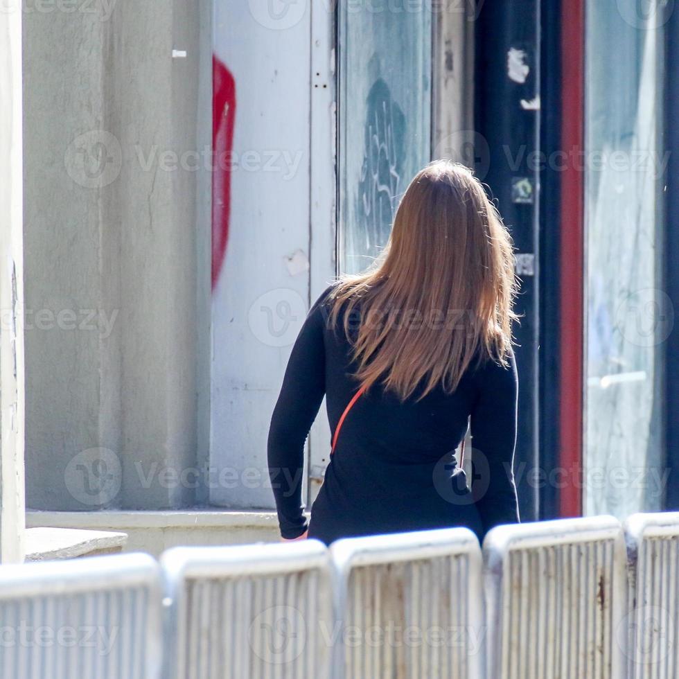 donna a piedi su il strada su un' soleggiato giorno foto