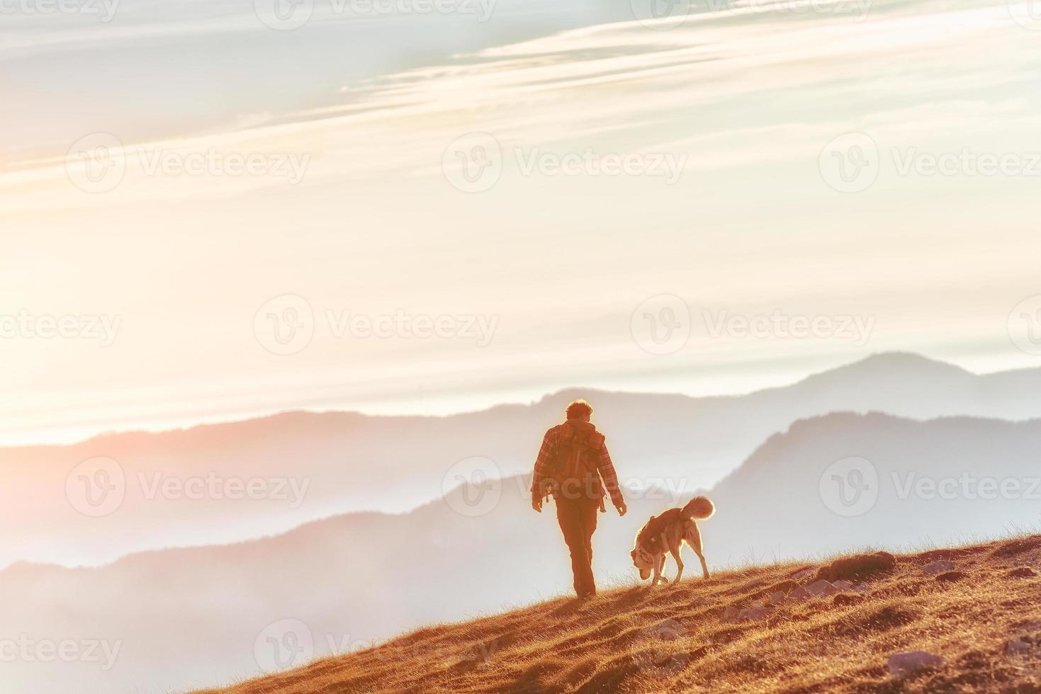 uomo a piedi con il suo cane nel il montagne foto