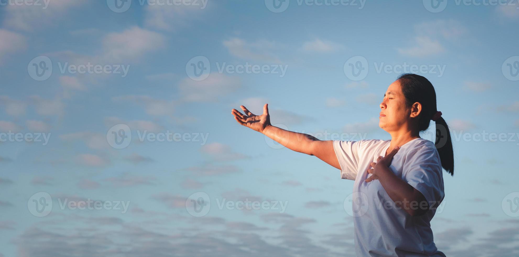 bandiera con copia spazio di donna mani preghiere per Dio su natura sfondo. panorama di femmina persona culto con fede e amore. concetto di religione, cristianesimo, fede, pace, speranza foto