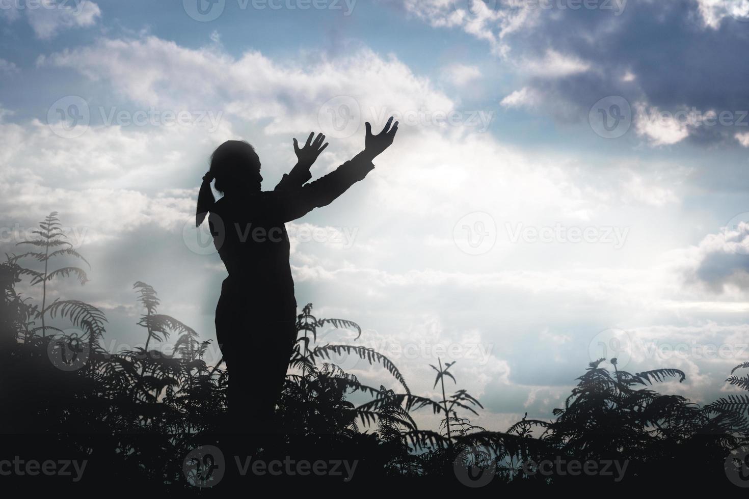 Cristo religione e cristianesimo culto o pregare concetto.silhouette di cristiano cattolico donna siamo preghiere per Dio nel buio cielo. preghiera persona mano nel natura sfondo. ragazza credere e fede nel Gesù foto