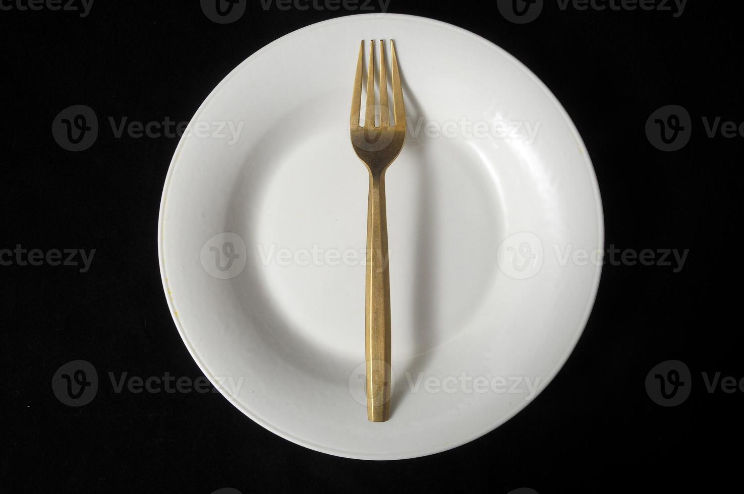 metallo forchetta e piatto su nero sfondo foto