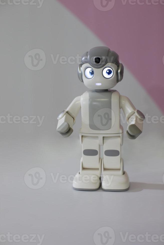 figurina di un' piccolo robot su un' grigio sfondo. foto