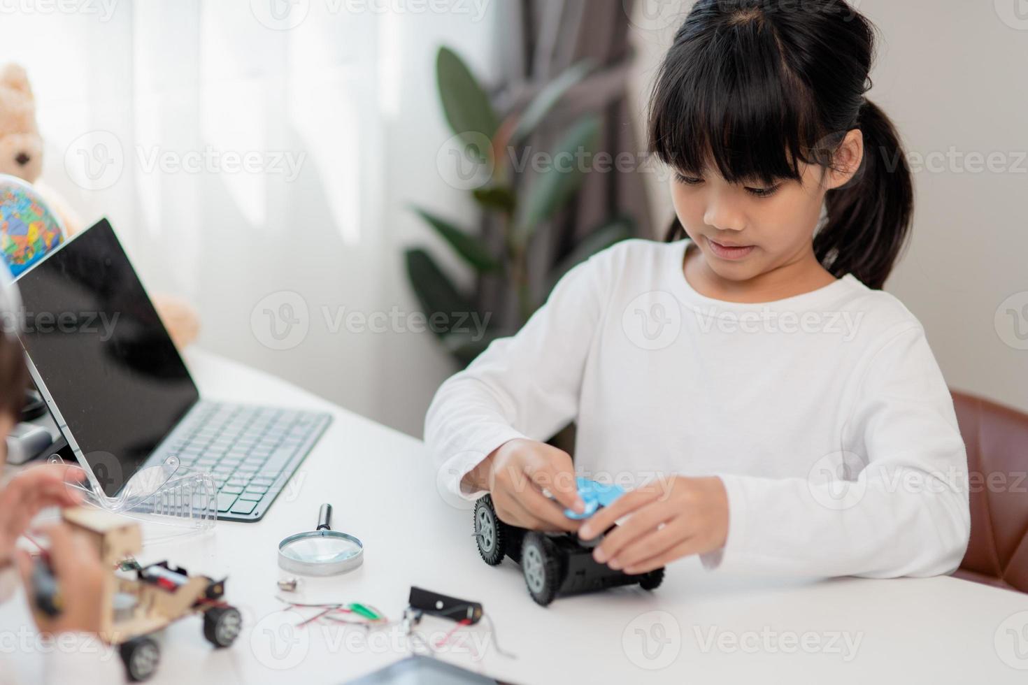 gli studenti asiatici imparano a casa a codificare auto robot e cavi di schede elettroniche in stelo, vapore, matematica ingegneria scienza tecnologia codice informatico in robotica per bambini concetto. foto