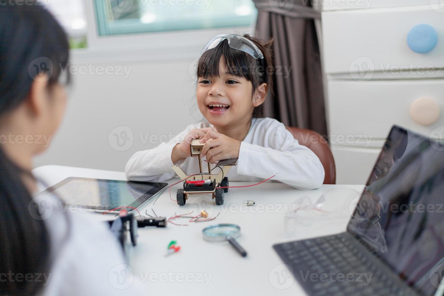 gli studenti asiatici imparano a casa a codificare auto robot e cavi di schede elettroniche in stelo, vapore, matematica ingegneria scienza tecnologia codice informatico in robotica per bambini concetto. foto