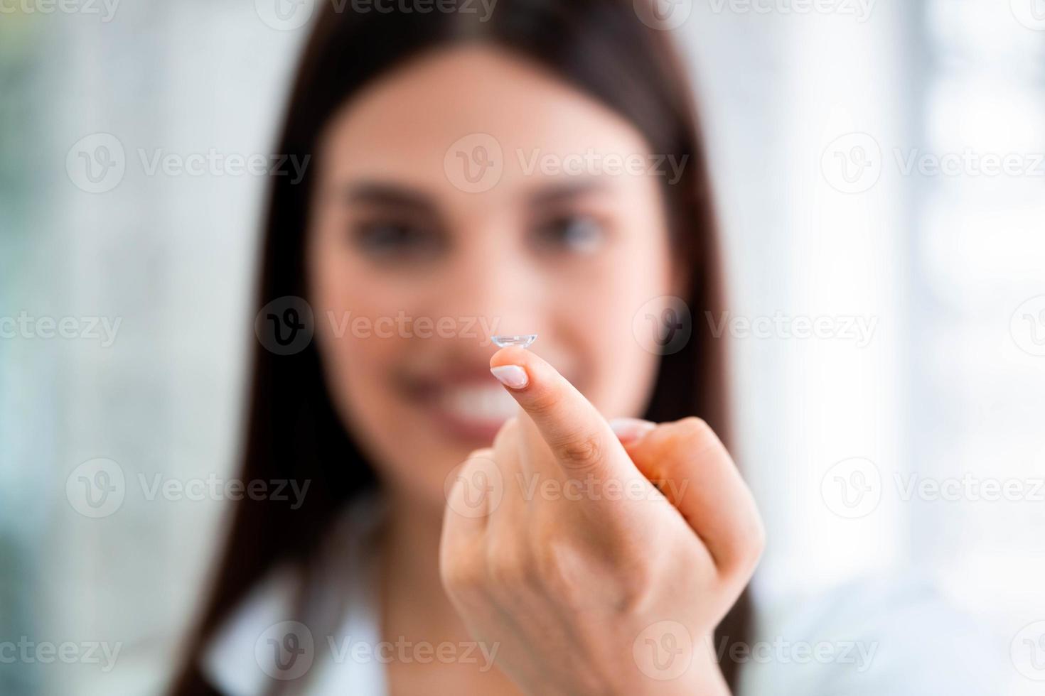 contatto lente su femmina dito, vicino su Visualizza. medicina e visione concetto foto