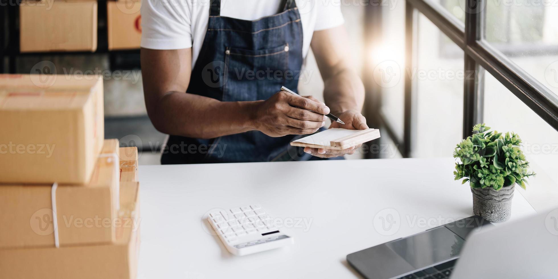 avviare piccolo attività commerciale pmi proprietario uomo imprenditori, Scrivi il indirizzo su ricevuta scatola e dai un'occhiata in linea ordini, preparare per imballare scatole, vendita in linea, commercio elettronico, pmi attività commerciale in linea concetto. foto