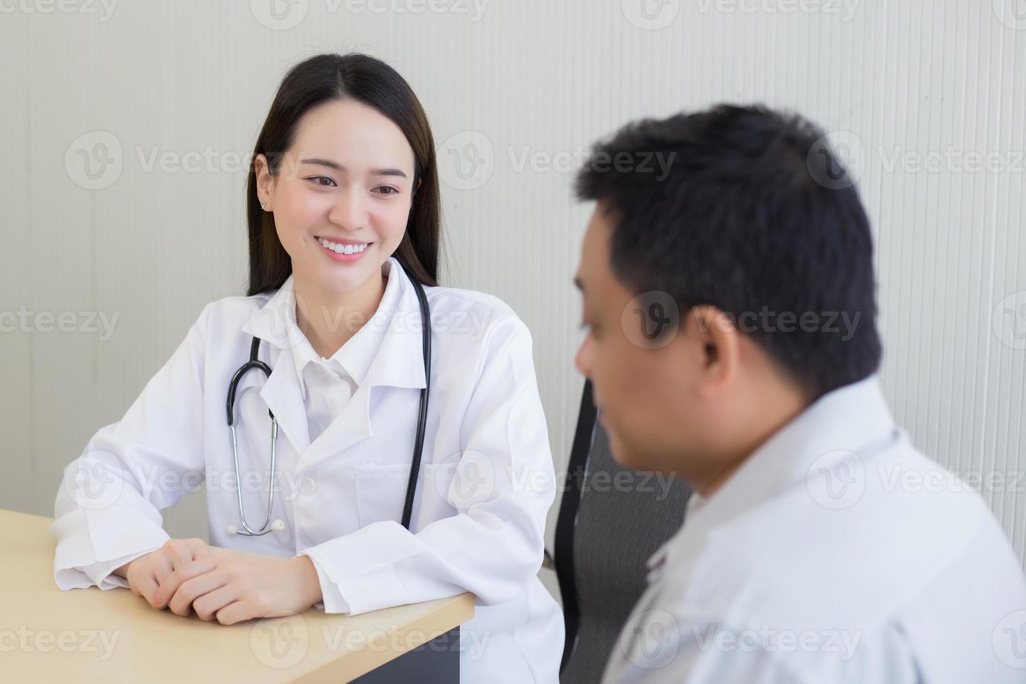 asiatico donna medico Sorridi e incoraggiare per un' uomo paziente. foto