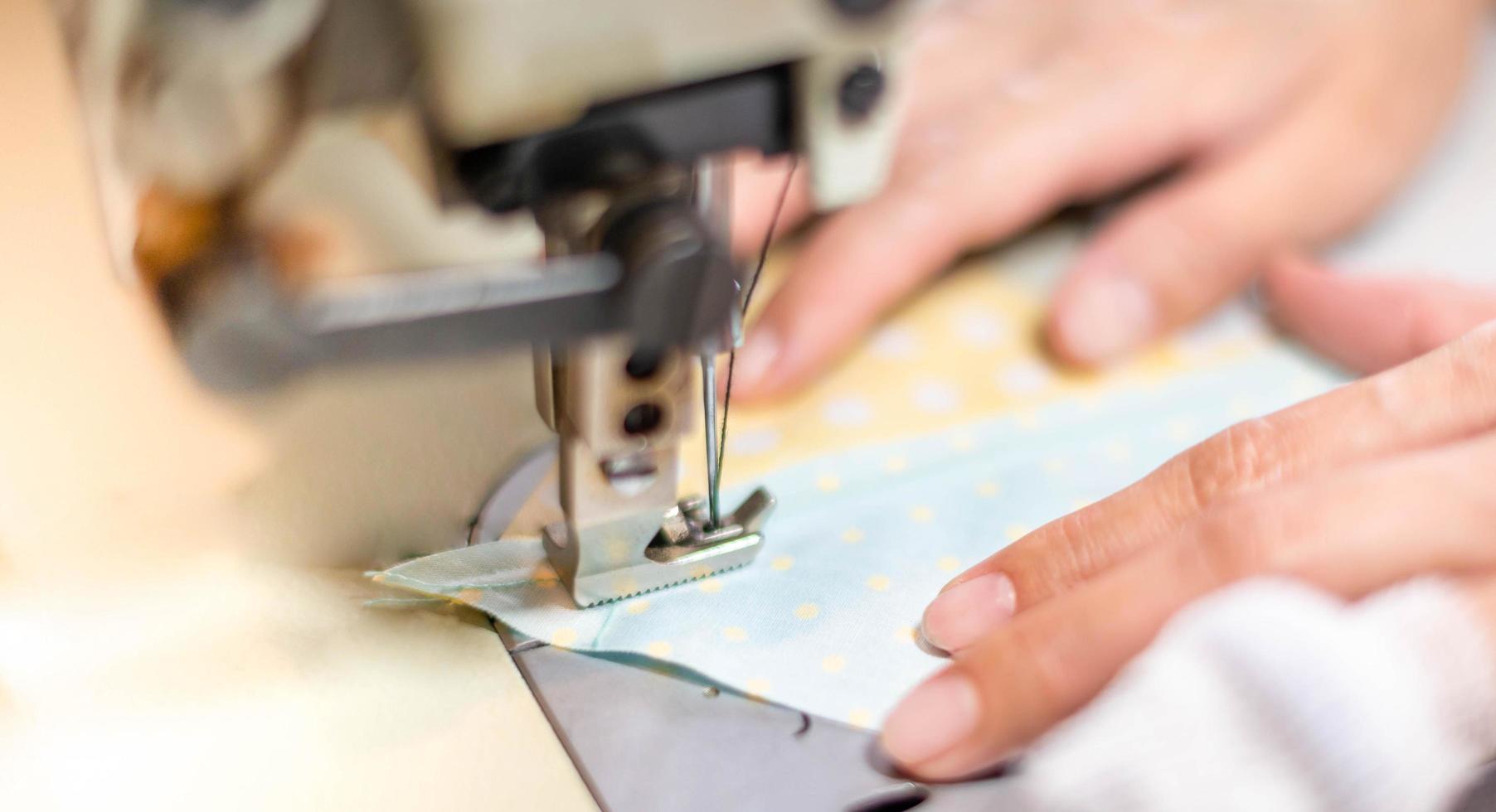 avvicinamento il femmina mano uso cucire macchina e cotone tessuto a il vecchio cucire macchina con Vintage ▾ stile. foto