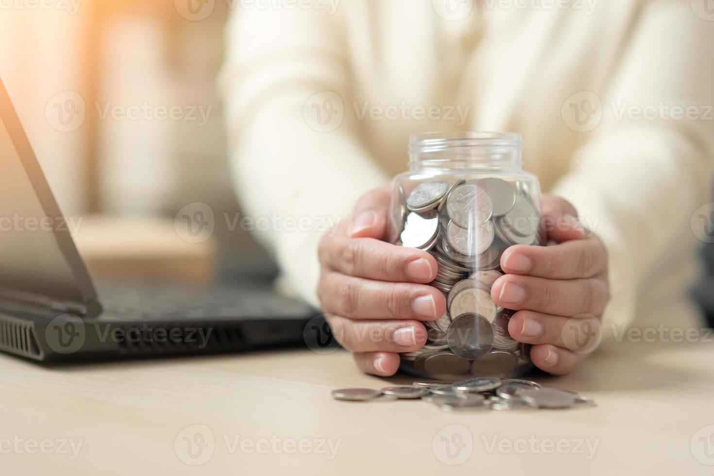 Lavorando donna e un' vaso pieno con tailandese moneta monete. concetto di opera difficile Salvataggio di più. foto