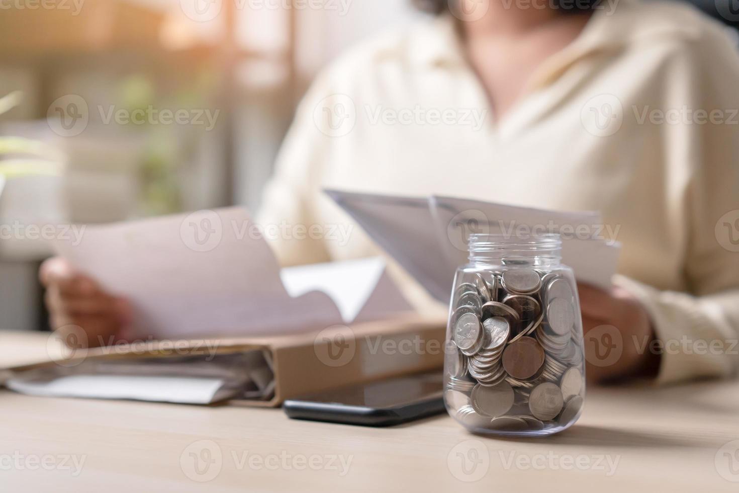 Lavorando donna e un' vaso pieno con tailandese moneta monete. concetto di opera difficile Salvataggio di più. foto