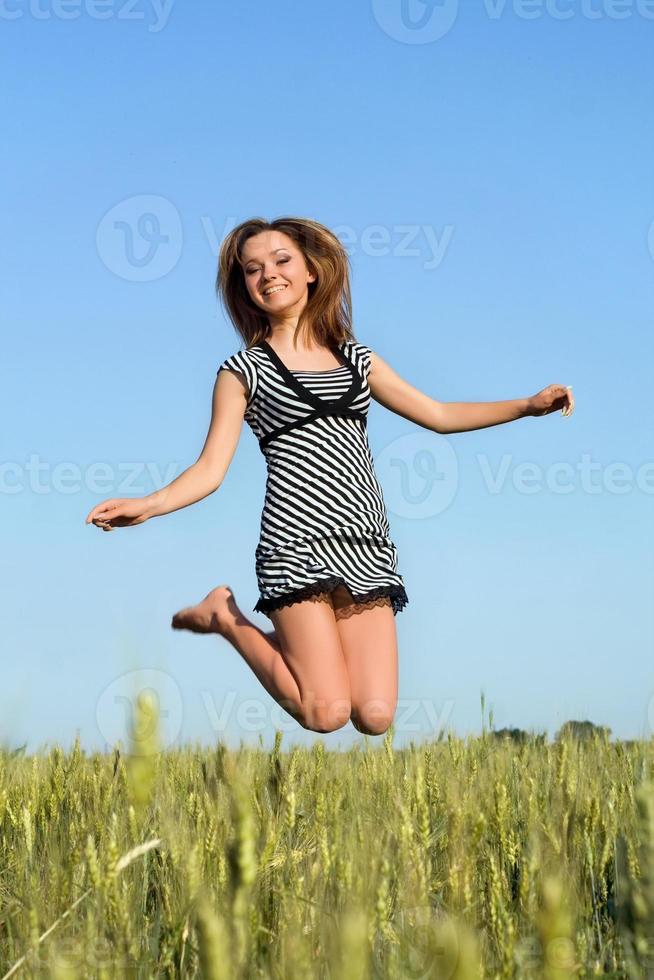 attraente ragazza salto nel campo foto