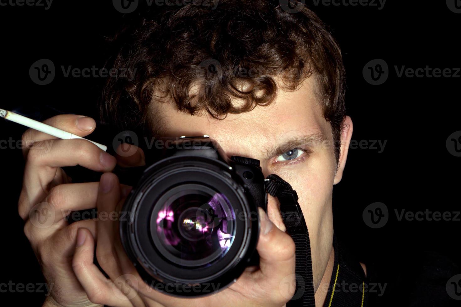 il giovane uomo - fotografo dietro a opera. isolato su un' nero sfondo 4 foto