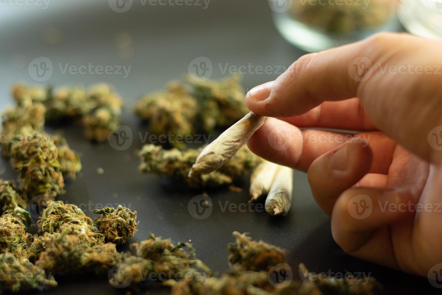 droga dipendenza concetto, uomo Tenere marijuana comune nel mano. copia spazio sfondo con canapa mini cuffie. erba fumo routine foto