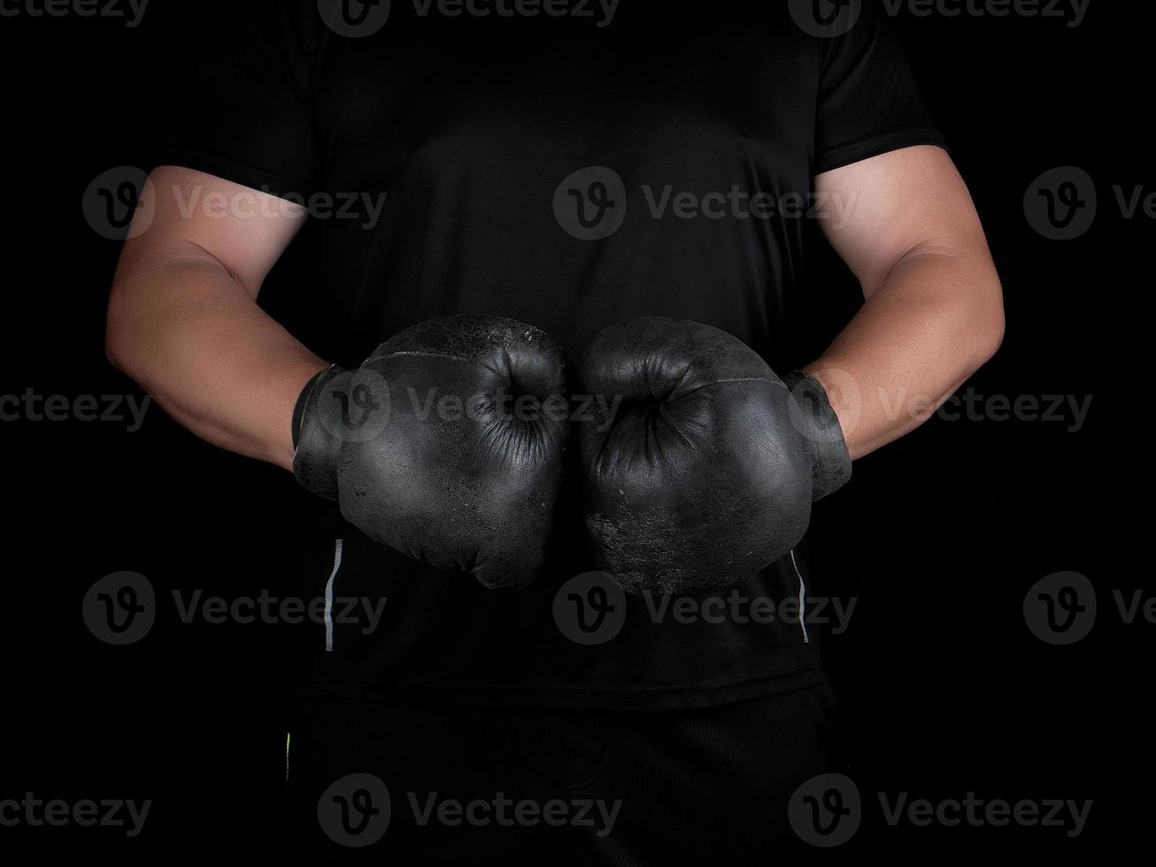 uomo sta nel un' boxe cremagliera, indossare molto vecchio Vintage ▾ nero boxe guanti foto