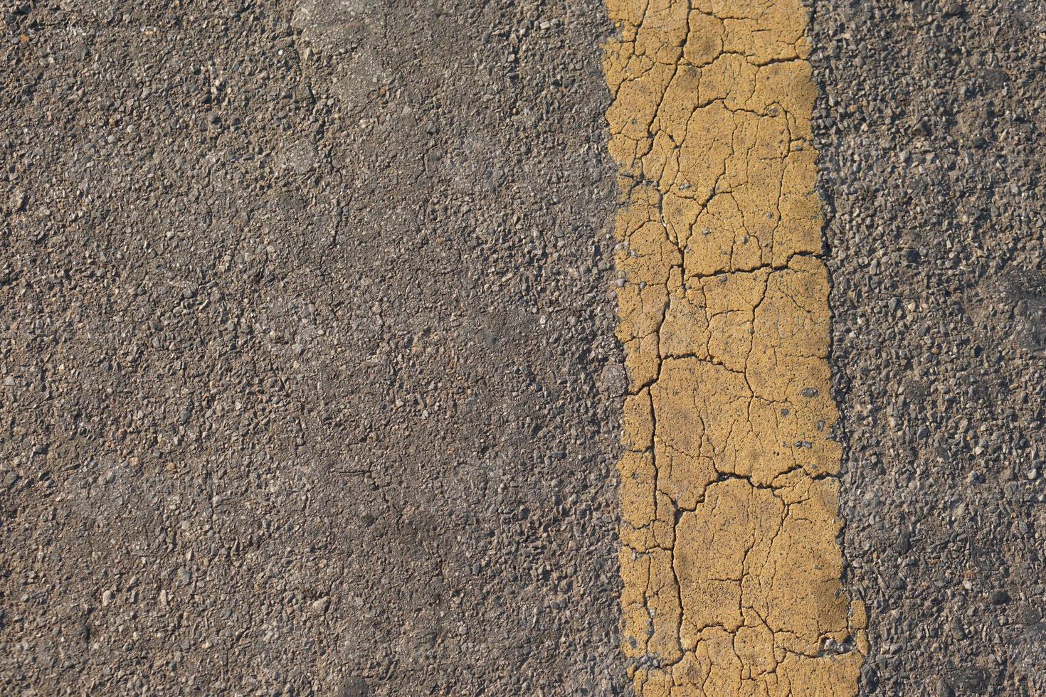 giallo linea sfondo con crepe su il vecchio strada foto