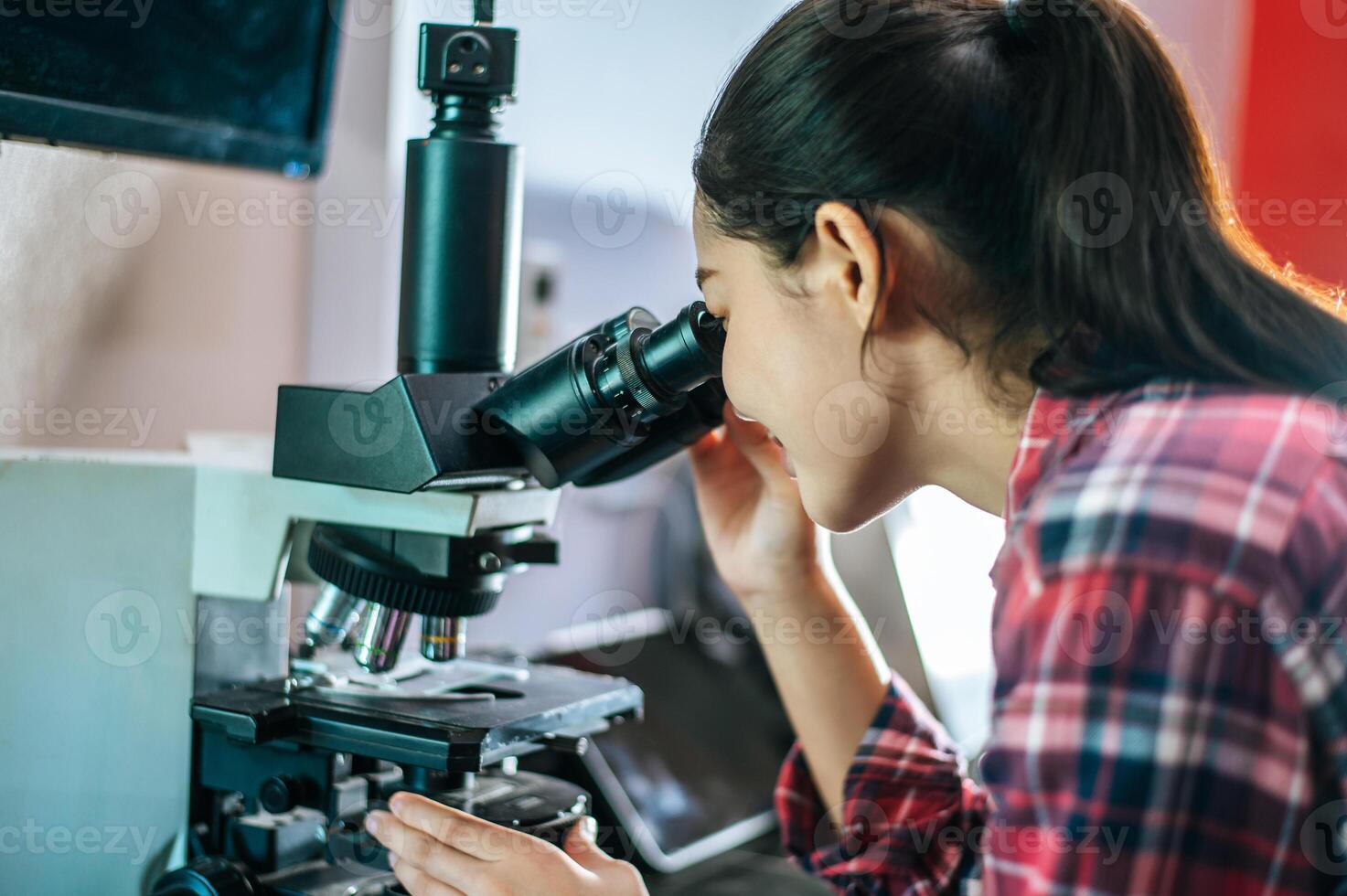 asiatico giovane femmina contadino guardare attraverso un' microscopio nel un' laboratorio. moderno tecnologie nel agricoltura gestione, agribusiness e ricerca concetto. foto