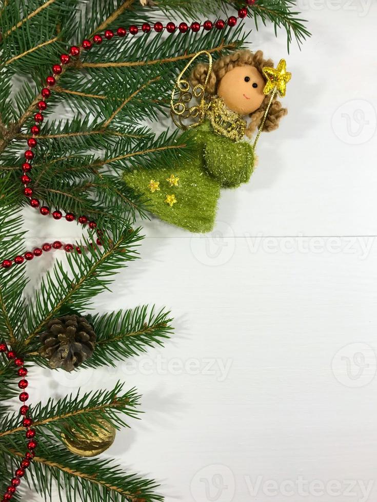 ramo di un' Natale albero con coni e Fata giocattolo su un' bianca di legno sfondo foto