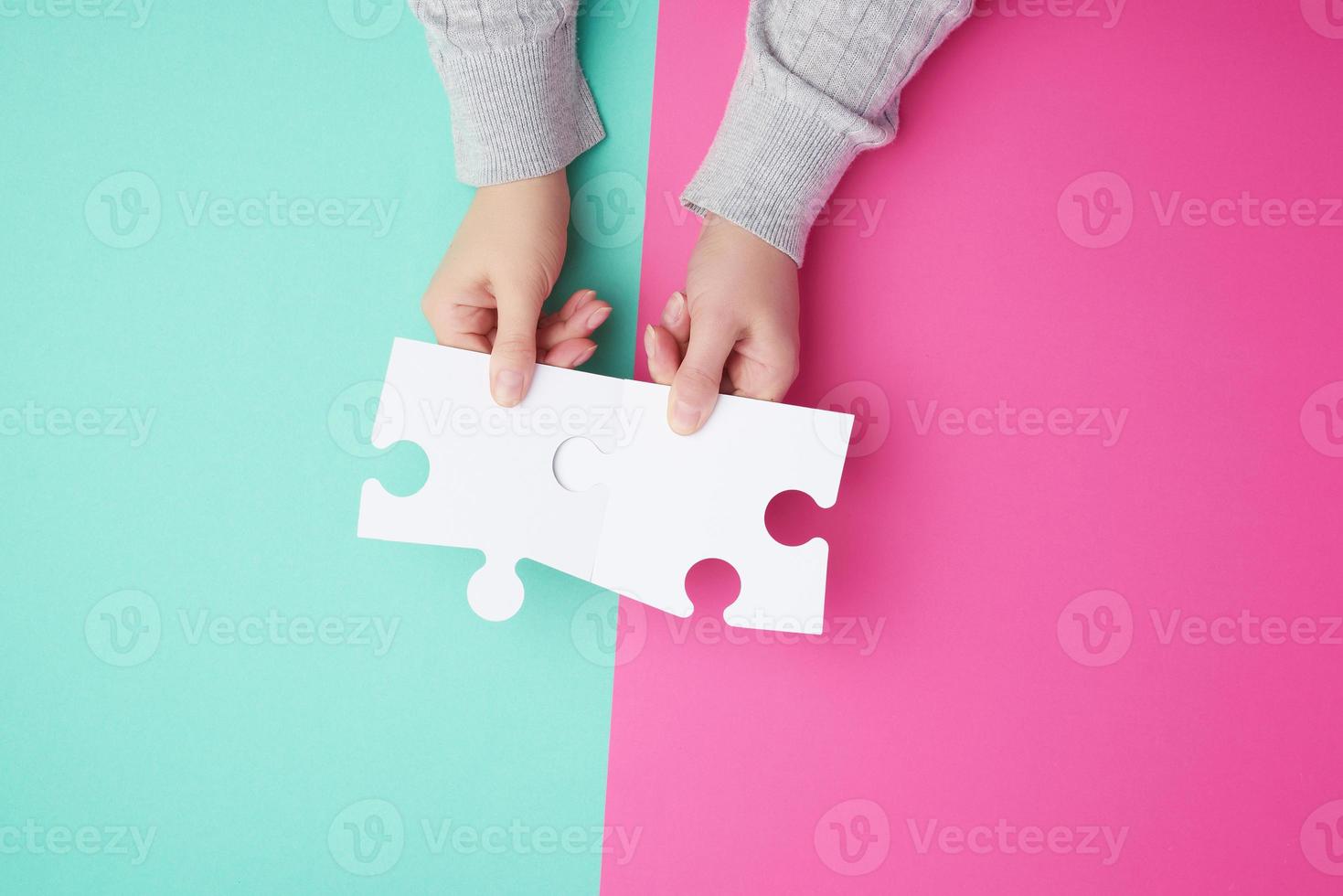 Due vuoto carta bianca pezzi di puzzle nel femmina mani, puzzle collegato foto
