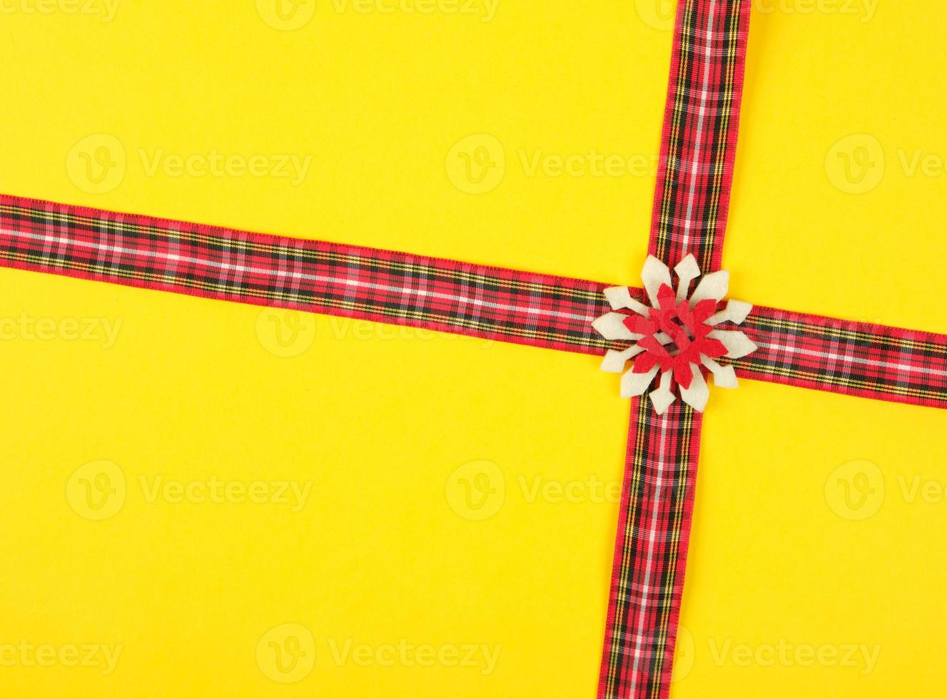 rosso decorativo nastro nel un' scatola attraversare su un' attraversare su un' giallo sfondo foto