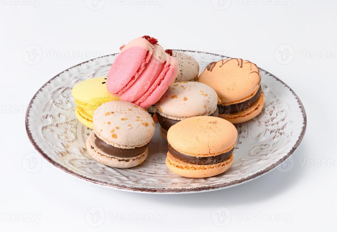 al forno mandorla macarons su un' bianca ceramica piatto, bianca sfondo foto