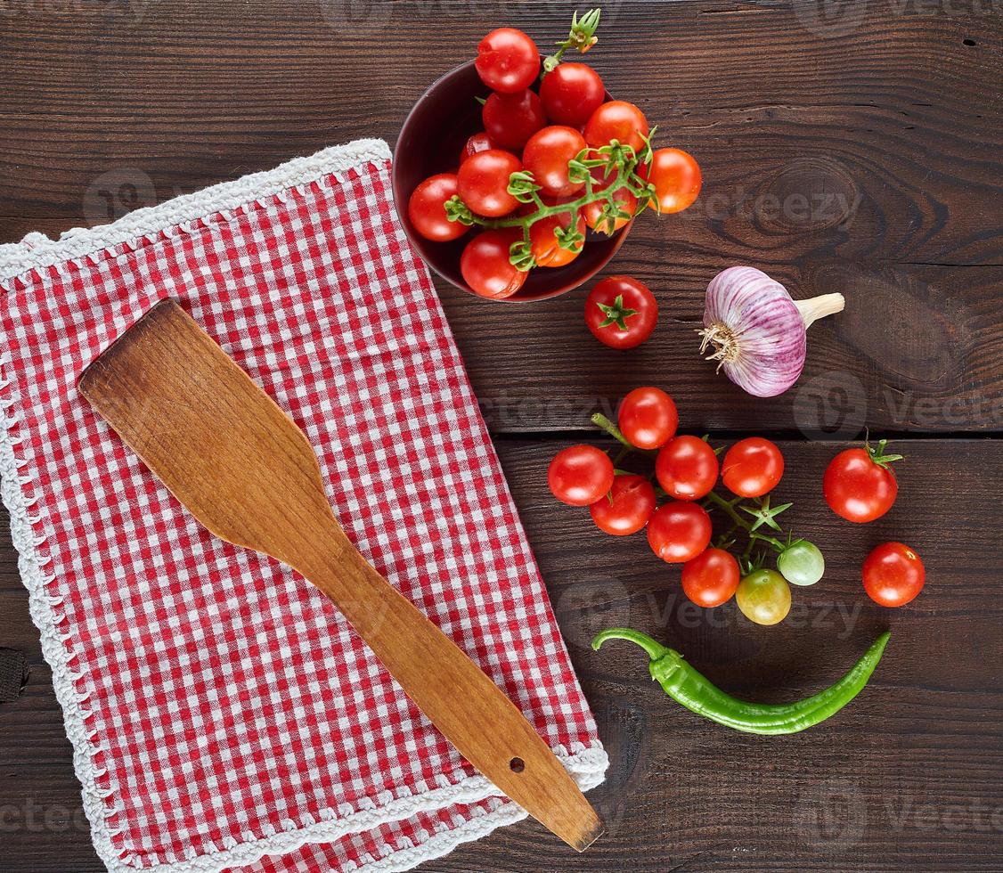 rosso tessile cucina asciugamano nel un' gabbia e fresco ciliegia pomodori foto