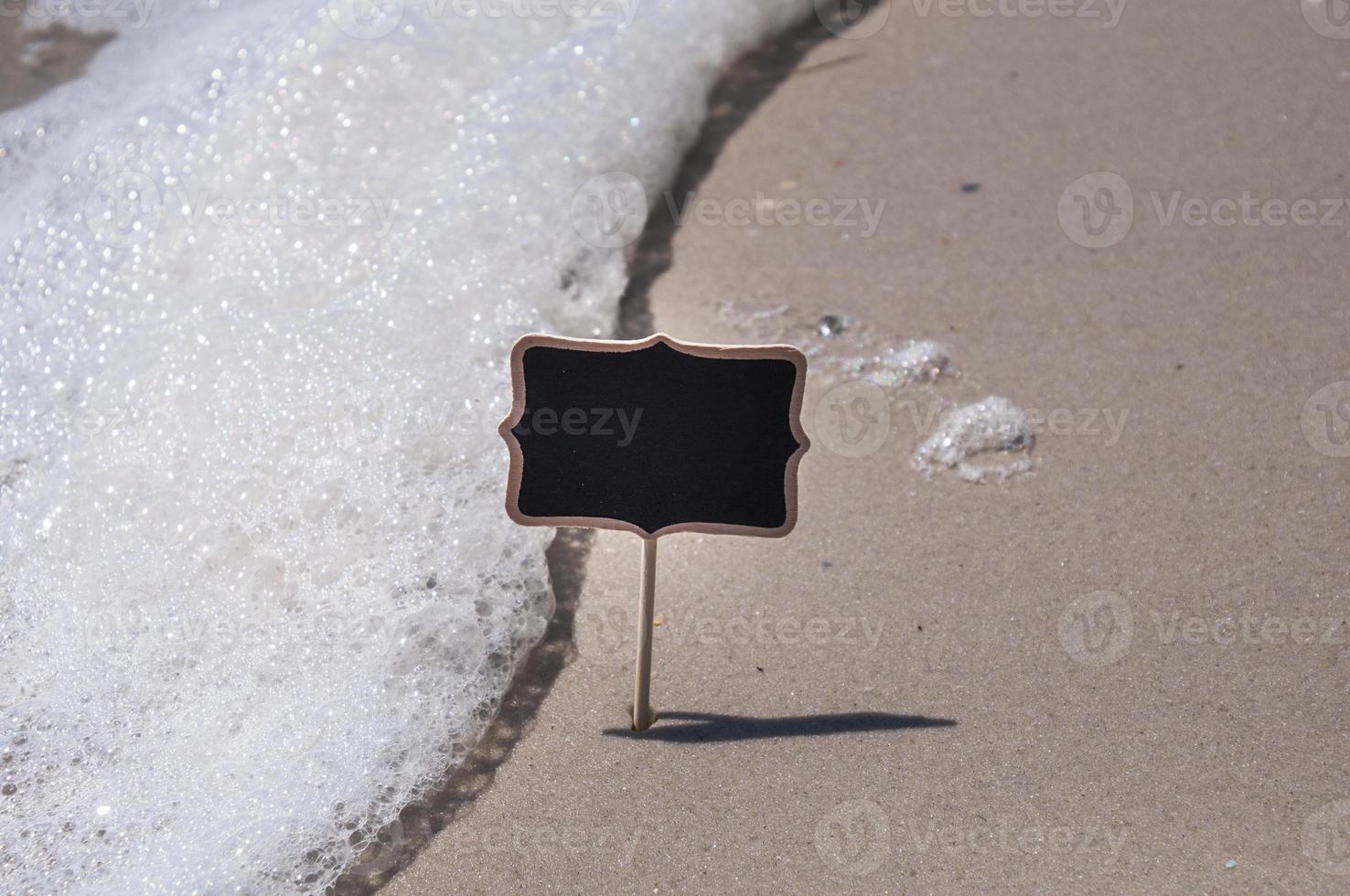 vuoto di legno nero cartello su il spiaggia foto