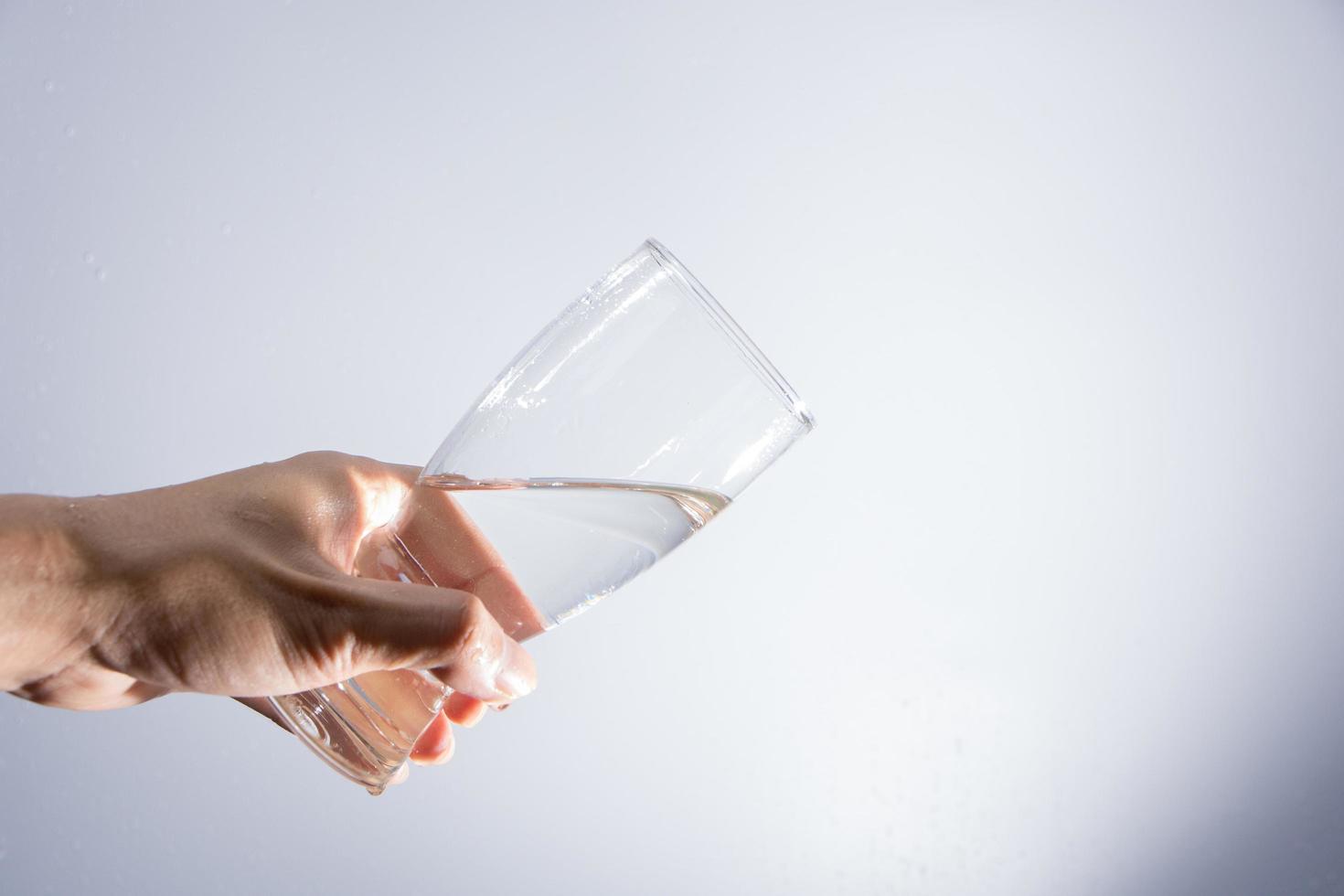 versando acqua dal bicchiere foto