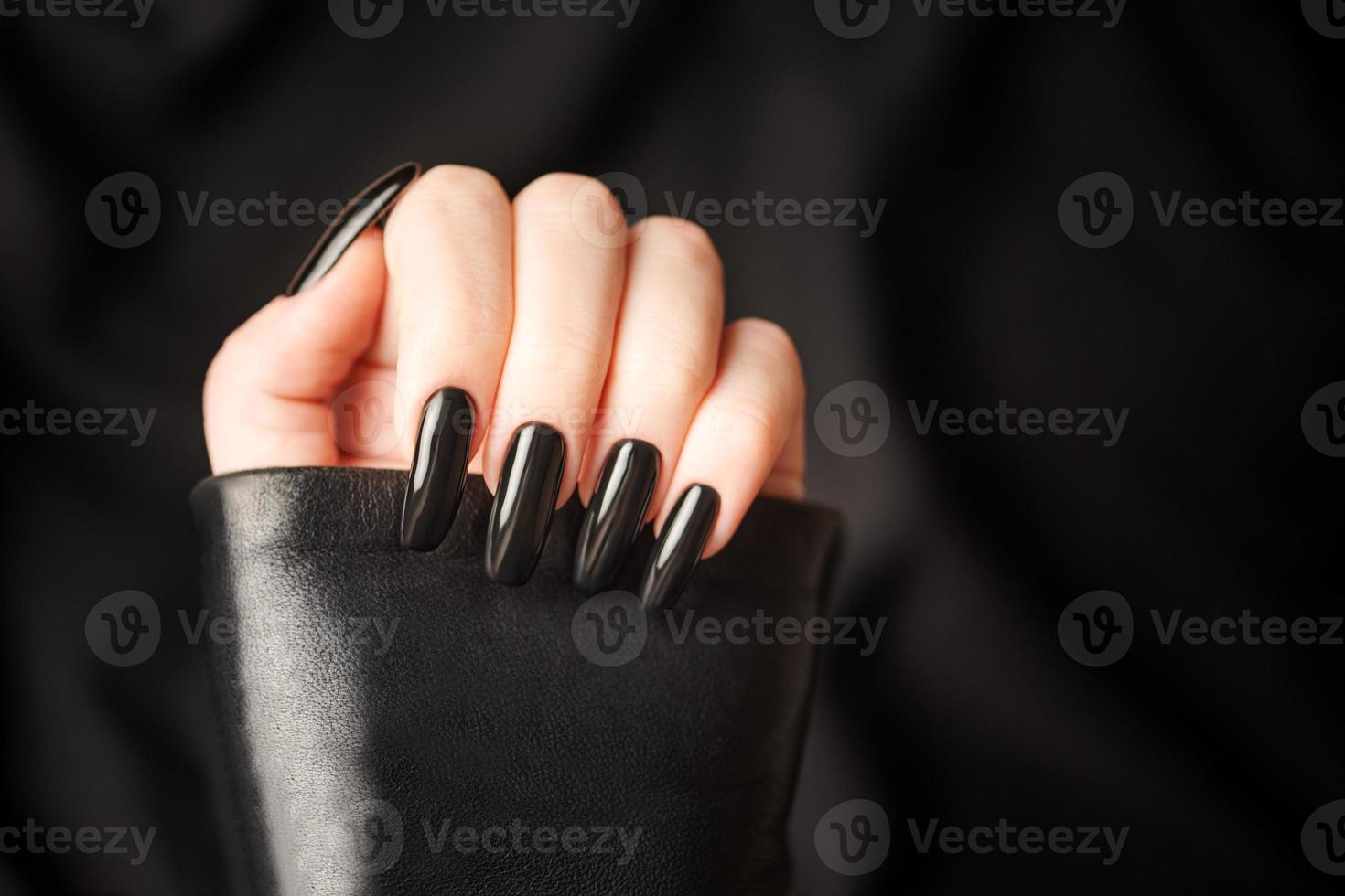 mani di un' giovane ragazza con nero manicure su Chiodi foto