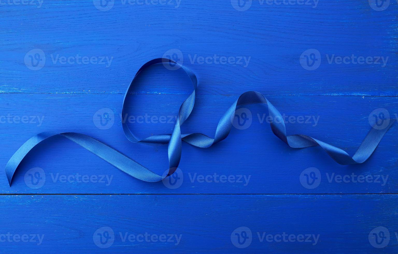 contorto seta blu nastro su un' blu di legno sfondo foto