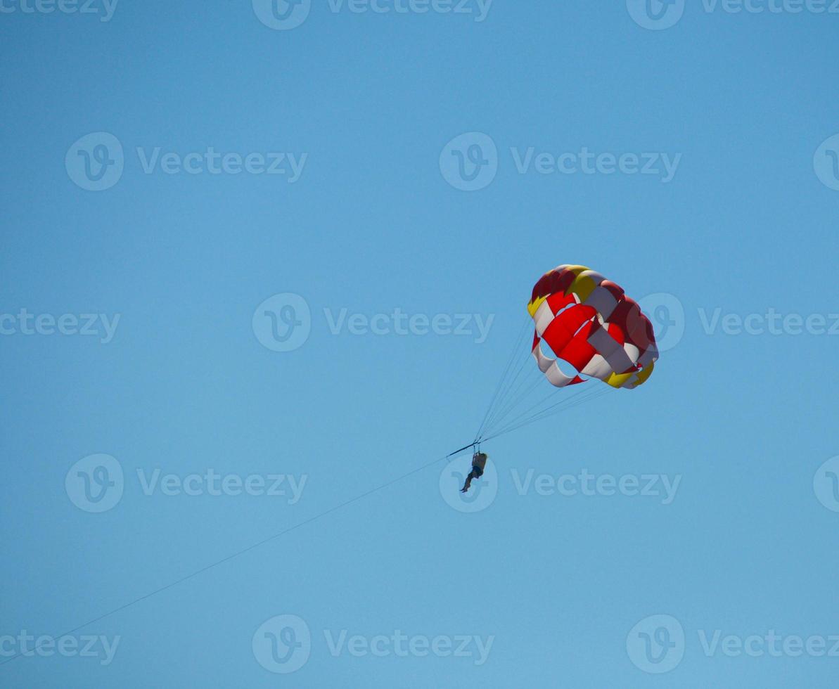 paracadute contro il fondale di chiaro cielo foto